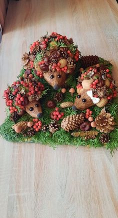 three deer figurines made out of pine cones and berries