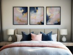 a bedroom with two paintings above the bed