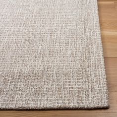 a white rug on the floor with wood floors in the background and an area rug that looks like it has been made out of wool