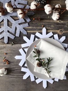 a white plate topped with napkins next to snowflakes and cotton floss