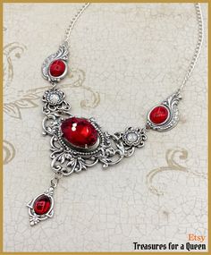 A Victorian Gothic Ruby Red Crystal Edwardian Antique Vintage Inspired Necklace with Silver Plated brass Filigrees and Swarovski Crystal Rhinestones: This item will be made just for you and may take 3 to 5 days to ship Inspired by the lush extravagance of Victorian Era jewelry combined with fantastical Gothic flair, this necklace isn't for the faint of heart.  This necklace is made using several different vintage inspired filigrees all of which are Silver Plated brass which I have polished and given a coat of Renaissance Wax. The center stone is an 18x13mm oval crystal in a beautiful cherry red color. On each side of the center piece are matching cherry red 10x8mm cabochons and dangling from the center is another smaller (8x6mm) matching red cabochon. Throughout the necklace are clear Swar Red Metal Filigree Jewelry, Red Gothic Metal Necklace, Red Gothic Necklace For Formal Occasions, Red Pendant Necklace With Vintage Charm, Red Necklace With Vintage Charm As A Gift, Red Vintage Charm Necklace For Gift, Red Necklace With Vintage Charm For Gift, Gothic Red Necklace For Valentine's Day, Gothic Jewelry For Valentine's Day Formal