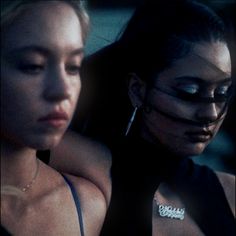 two young women are staring at something in the distance with their eyes closed and one woman has her face painted black