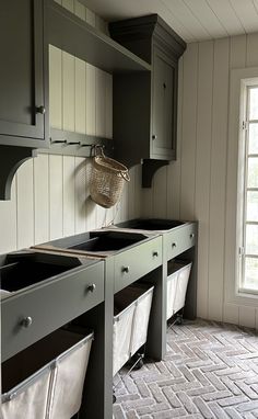 a kitchen with gray cabinets and white tile on the floor next to an open window