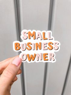 someone holding up a small business owner sticker in front of a metal door with the words small business owner on it