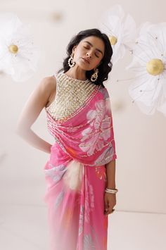 The indo-western set comes with a heavily embroidered blouse with attached pallu and a mid drape skirt. The blouse and the attached pallu is adorned with sequins and pearls. Traditional Georgette Pre-draped Saree With Pearl Embroidery, Festive Draped Sequin Dupatta, Traditional Drape Georgette Blouse For Eid, Georgette Blouse With Traditional Drape For Eid, Draped Georgette Traditional Wear With Mirror Work, Traditional Chinon Blouse With Dupatta, Embellished Georgette Pre-draped Saree For Navratri, Diwali Sequined Traditional Drape Blouse Piece, Silk Draped Blouse With Mirror Work