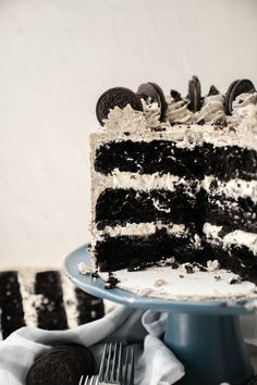 a slice of oreo cake is on a plate with a fork and cookies around it