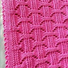 a pink knitted blanket sitting on top of a table