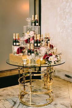 a glass table topped with lots of bottles and glasses filled with wine on top of it