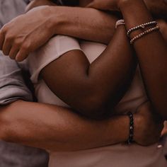 two people hugging each other with their arms wrapped around them