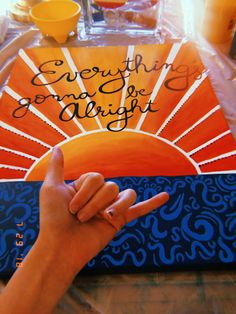 a hand is pointing at an orange and blue book with the words everything comes to bright written on it