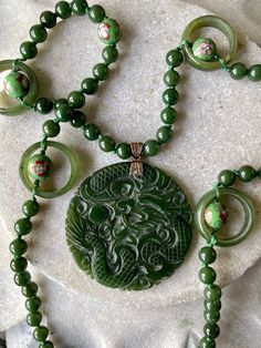 Stunning Carved Green Jade Dragon Cloisonne Long Vintage Necklace Measures 24 inches around not including pendant Carved Medallion Necklace For Jewelry Making, Carved Medallion Necklaces For Jewelry Making, Bohemian Single Strand Round Jewelry, Adjustable Round Carved Necklaces, Green Spiritual Single Strand Jewelry, Green Bohemian Single Strand Jewelry, Bohemian Green Single Strand Jewelry, Green Single Strand Round Jewelry, Adjustable Carved Round Necklace