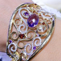 This stunning bangle has 171 round diamonds (1.64cts), 3 green amethysts (1.68cts), 3 garnites (0.63cts, and 4 purple amethysts (6.68cts). The diamonds are pave set, and the colored stones are prong set. All jewelry sales come with an appraisal including replacement value. For more visit our website: www.matineejewelryinc.com Elegant Bangle With Gemstone Accents, Luxury Cuff Bracelet Bangle With Gemstone Accents, Elegant Diamond Bangle With Gemstones, Elegant Multi-stone Bangle For Anniversary, Elegant Multi-stone Bracelet For Anniversary, Luxury Wedding Bracelets With Gemstone Accents, Elegant Multi-stone Bracelets For Anniversary, Luxury Oval Gemstone Bangle, Luxury Gemstone Accents Bangle For Gift