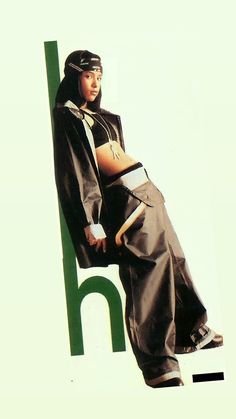 a woman is leaning against a green and white sign with the letter h on it