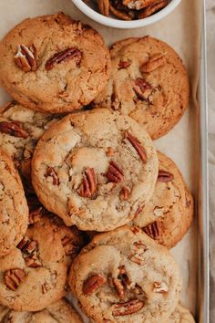 a tray full of cookies and pecans next to a bowl of pecans