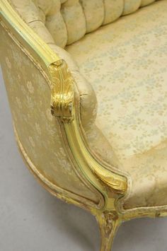 an antique style couch with gold trimming