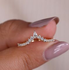 a woman's hand holding a diamond ring