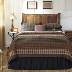 a bed with plaid comforter and pillows in a room