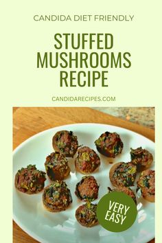 a white plate topped with stuffed mushrooms on top of a wooden table