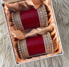 two red bracelets in a box on a white furnishing