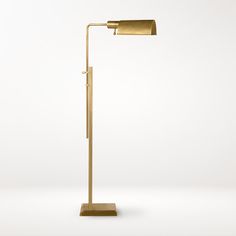 a gold floor lamp on a white surface with a dim light coming from the top