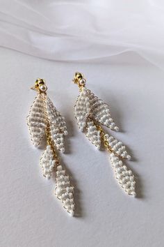 Delicate, Handmade ALAYA Wedding Earrings Dreaming of unique jewelry for your wedding? Our handmade earrings are the perfect choice!  Crafted from high-quality materials: gold-plated wire, pearly seed beads, and hypoallergenic stainless steel studs, they will enchant you with their delicate beauty.  Thanks to the two-part design, you can wear them both long and short, adapting them to any style. Ideal for weddings, but also for many other occasions. Earrings measurement: * Full length: approx 8cm (3.15") * Short part length: approx 3.3cm (1.3") Matching Items:   See Other EARRINGS: https://www.etsy.com/shop/martalilyjewellery/?etsrc=sdt&fbclid=PAZXh0bgNhZW0CMTEAAabSJ6QrVgLVFeGJhsEoqw9viOlBSQ6EGWor-p_Zyv4UQ0idJ2NciFsHfdg_aem_SD41An-A-HJk9DPh-CSeDQ&section_id=40157901 CARING FOR GOLD-PLATED Beaded Wedding Earrings, Minimalist Wedding Earrings, Wedding Drop Earrings, Wedding Earrings Drop, Delicate Beauty, Beaded Wedding, Earrings Minimalist, Stunning Earrings, Minimalist Wedding