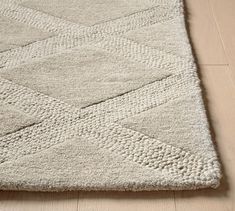 a white rug on the floor with an interesting diamond pattern in the middle and bottom