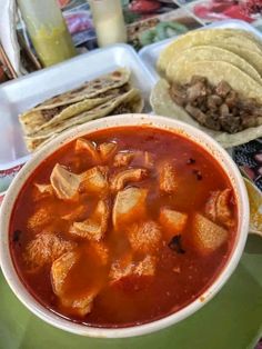 a bowl of soup with tortillas on the side