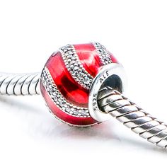 Authentic Pandora Adornment Sterling Silver Charm With Red Enamel And Clear Zirconia 791991EN07 - Retired. A bright red hue and a striking stone-studded ribbon embellishment gives this sterling silver charm a lavish expression. Red is the color of passion and draws attention like no other, radiating a strong and powerful energy that invokes us to take action. A beautiful touch for a Christmas themed bracelet too. This item is retired from production and may be difficult to find. Charm is pre-own Silver Bedazzled Jewelry As Gift, Silver Bedazzled Jewelry For Gift, Silver Bedazzled Jewelry Gift, Classic Red Jewelry With Diamond Accents, Red Jeweled Cubic Zirconia Jewelry, Red Jeweled Jewelry In Cubic Zirconia, Red Jeweled Jewelry For Anniversary, Red Embellished Party Jewelry, Red Sparkly Jewelry For Formal Occasions