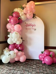 balloons and flowers decorate the entrance to a bridal tea party