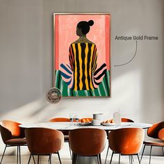 a dining room table with orange chairs and an art piece on the wall above it