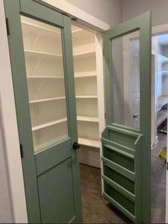 an empty room with green doors and shelves