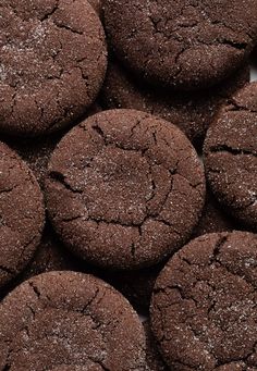 chocolate cookies with powdered sugar on them are arranged in a pile and ready to be eaten