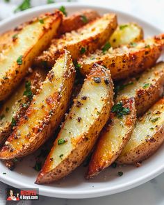 baked potato wedges on a white plate with parsley sprinkled on top