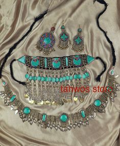 We call this the "Baran Set" - It translates to rain.  This is a traditional jewelry set originated and inspired by classic Afghan fashion. This set contains 5pcs: Necklace, Pair of earrings, belt and a Matika (Headpiece).  Colors: Silver and Blue  Necklace: 6.5 " drop Earrings:  4 " Matika: 5 " Belt: 49 " Please note: As this piece is completely handmade, minor discrepancies may be present. These imperfections contribute to making it a unique and one-of-a-kind piece.  Care Instructions: Clean t Balochi Doch Jewelry, Bohemian Silver Jewelry Sets With Stone Work, Adjustable Turquoise Bohemian Jewelry Sets, Bohemian Ceremonial Jewelry With Stone Work, Traditional Turquoise Jewelry For Ceremonial Occasions, Traditional Adjustable Blue Jewelry, Bohemian Jewelry For Festivals With Stone Work, Bohemian Festival Jewelry With Stone Work, Bohemian Jewelry With Stone Work For Festivals