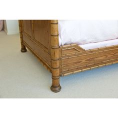 a bamboo bed frame with white sheets and pillows