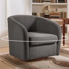 a gray chair sitting on top of a wooden floor next to a book shelf filled with books