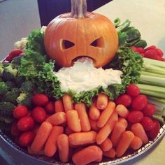 a bowl filled with carrots, celery and other vegetables next to a jack - o'- lantern