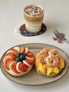 there is a sandwich with fruit and shrimp on it next to a cup of coffee