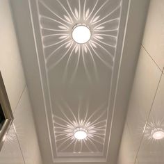 the ceiling in this bathroom is made up of white tiles and has a circular light fixture