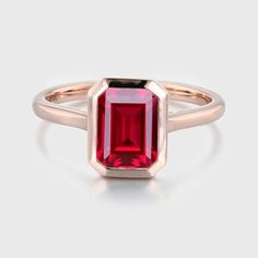 Experience the radiance of red with our Emerald Cut Lab Grown Ruby Engagement Ring in rose gold, a perfect solitaire choice for July birthstone enthusiasts. Classic Red Ring With Bezel Setting, Classic Red Rings With Bezel Setting, Classic Red Bezel Set Ring, Red Ruby Ring In 14k Gold With Bezel Setting, Rose Gold Emerald Cut Gemstone Birthstone Ring, Emerald Cut Rose Gold Birthstone Rings, Rose Gold Emerald Cut Birthstone Ring, Red Ruby Ring In 14k Rose Gold, Rose Gold Ruby Ring With Lab-created Gemstone