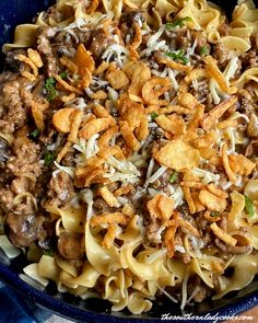 a blue bowl filled with pasta and meat