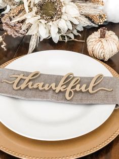 a white plate topped with a wooden sign that says,'grateful'on it