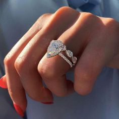 a woman's hand with a ring on it and an engagement band in the middle