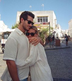 a man and woman hugging on the street