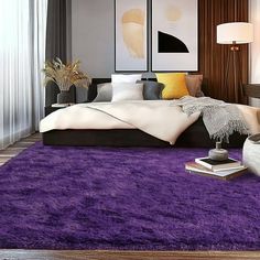 a bedroom with purple rugs and white bedding in the center, along with two lamps on either side