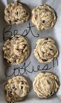 six chocolate chip cookies on top of a piece of parchment paper with the words best cookies written above them