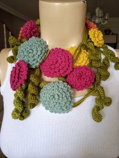 a crocheted flower necklace on a mannequin neckpiece with flowers in the center