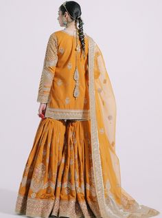 Traditional Orange Sharara Dress for Indian Bridal Wear in an elegant traditional Hot orange color raw silk sharara, detailing with riced Gotta, Zari, Sequence, and zardozi all over the outfit with a raw silk shirt. Shirt: Indulge in a mesmerizing composition of whimsical designs layered over this sparkling tangerine carrot shirt crafted in a traditional silhouette is gracefully enriched with exquisitely classic embroidery with signature motifs at the front, back, and sleeves in gold hues amalga Orange Sharara, Sharara Dress, Silk Sharara, Carrot Colour, Classic Embroidery, Desi Wedding Dresses, Hot Orange, Indian Bridal Wear, Desi Wedding