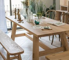 a wooden table with chairs and vases on it