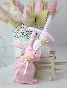 some pink and white stuffed animals sitting in front of a basket